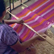 A member of the Cojolya Association weaves colorful textiles on a backstrap-loom